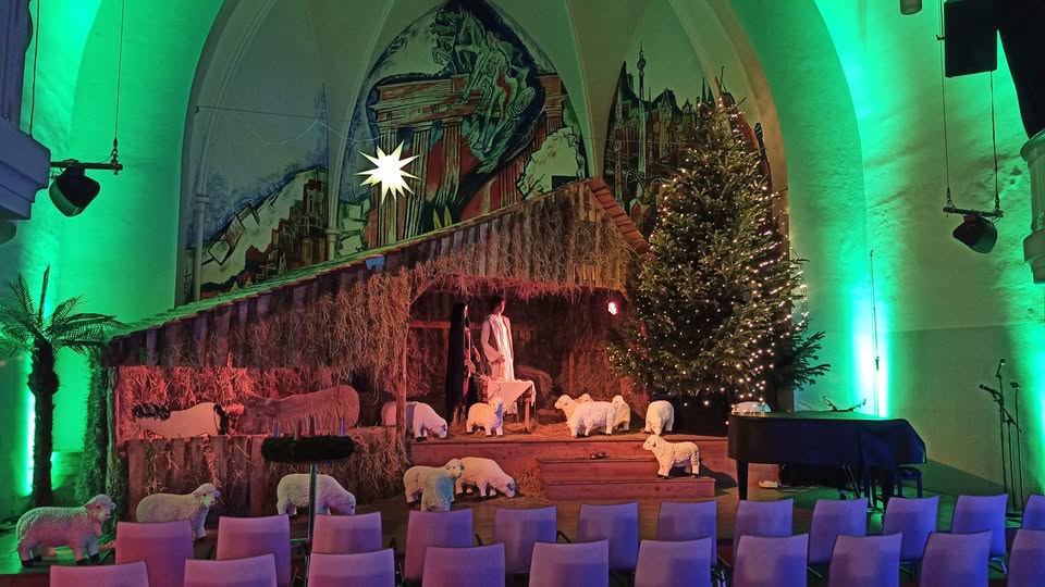 Der Kirchsaal ist mit schwarzer Plane verdunkelt und Strohballen bedecken den Fußboden. Den Besucher erwartet in der Friedenskirche Charlottenburg ein Kirchenbesuch der anderen Art: Mit Schafen und Engelserscheinungen werden die Umstände um die Geburt Jesu vor rund 2000 Jahren nacherlebt. Die Besucher erwartet eine Nachbildung der abenteuerlichen Reise der jungen Mutter Jesu. Schauspieler, menschengroße Puppen, orientalische Düfte, Lichtspots und der großer Stall von Bethlehem machen die Weihnachtsgeschichte mit allen Sinnen erlebbar und helfen, die Traditionen um Weihnachten zu ergründen. Bevor es losgeht, erfahren wir mehr über die Hintergründe der vielfältigen Traditionen und Sitten zu Weihnachten und befassen uns mit Themen wie: Adventskalender, dem Apfel am Baum, dem Weihnachtsbaum, Zimt, Lebkuchen und Weihnachtsliedern. Warum kommt am 24.12. der Weihnachtsmann? Warum ist er in einen roten Mantel gehüllt? Und vieles, vieles mehr.
